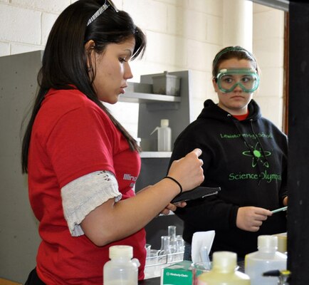 Melixa Rivera-Sustache (left) helps a high school student participating in the Materials Science competition.