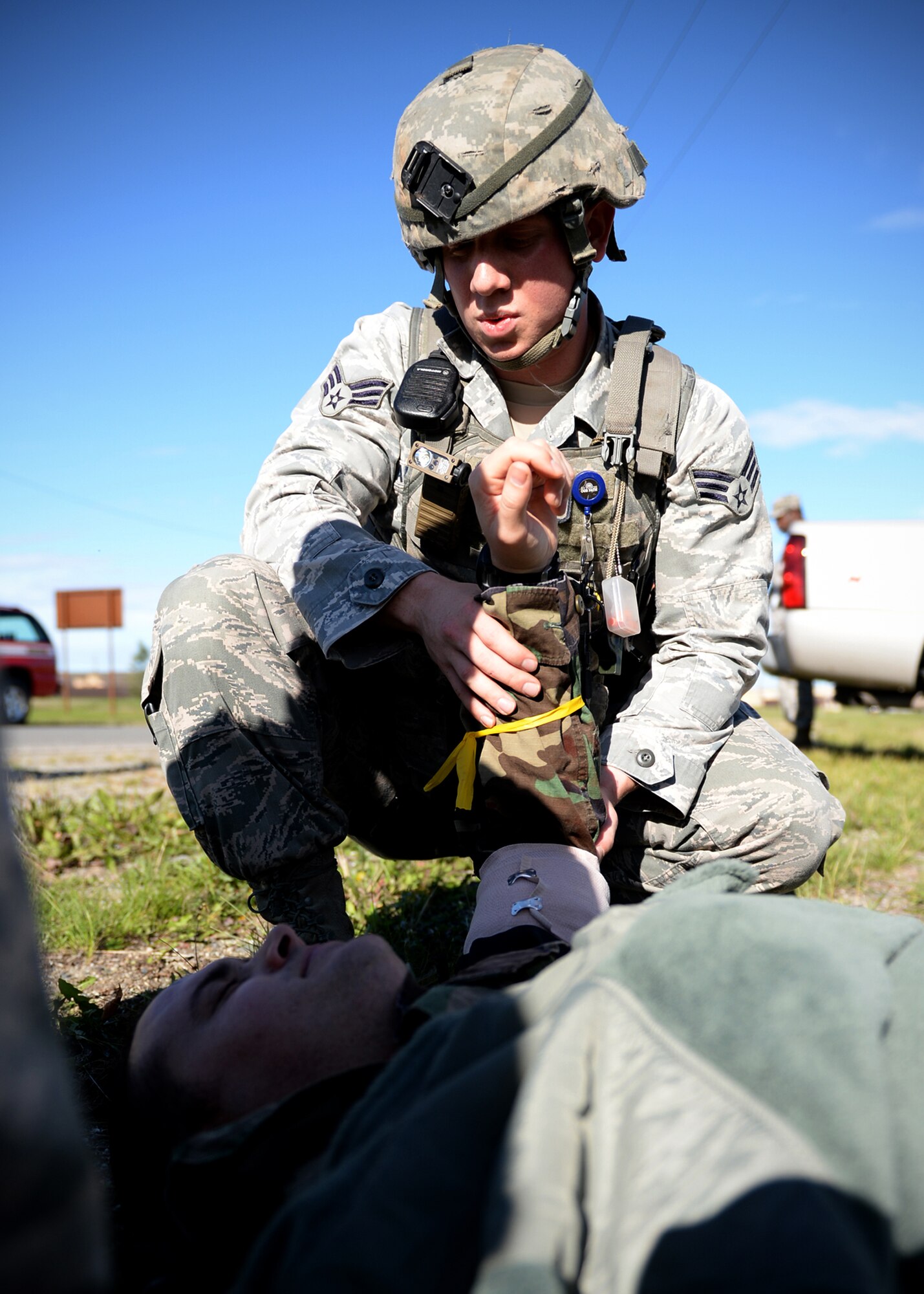 Senior Airman Sean Kearnely, 354th Security Forces response force leader, performs self-aid buddy care on a simulated victim during an active shooter exercise Sept. 10, 2013, Eielson Air Force Base, Alaska. Several base agencies responded to the scenario which is part of the Pacific Air Forces Readiness Focused Consolidated Unit Inspection to evaluate the base on readiness and compliance with operational instructions. (U.S. Air Force photo by Senior Airman Shawn Nickel/Released)