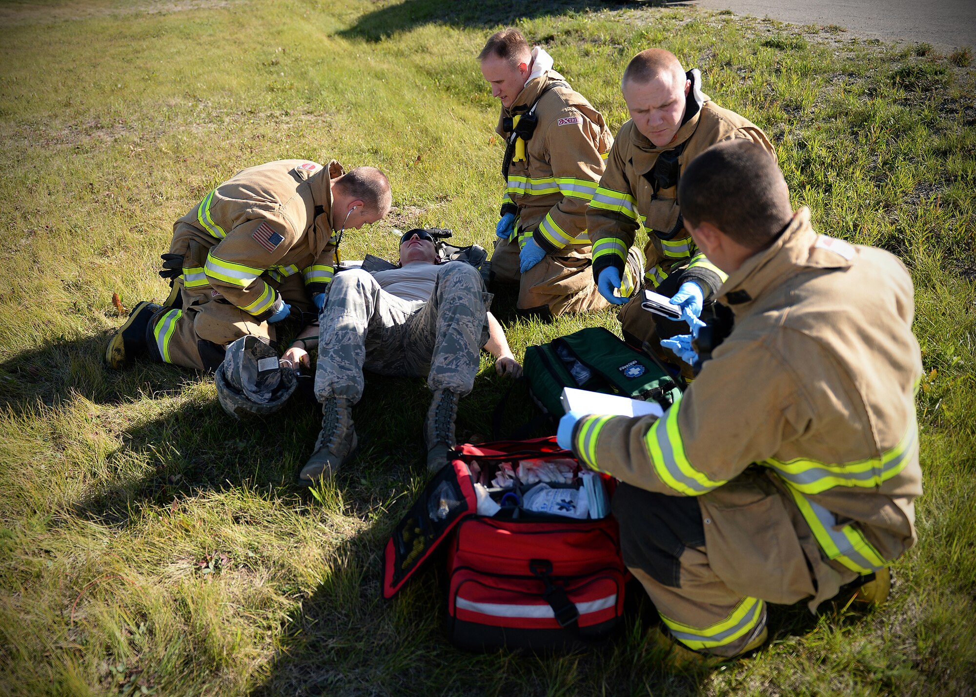 Fire fighters from the 354th Civil Engineer Squadron tend to a simulated victim during an active shooter exercise Sept. 10, 2013, Eielson Air Force Base, Alaska. The scenario is part of the Pacific Air Forces Readiness Focused Consolidated Unit Inspection, which evaluates the base on readiness and compliance with operational instructions. (U.S. Air Force photo by Senior Airman Shawn Nickel/Released)