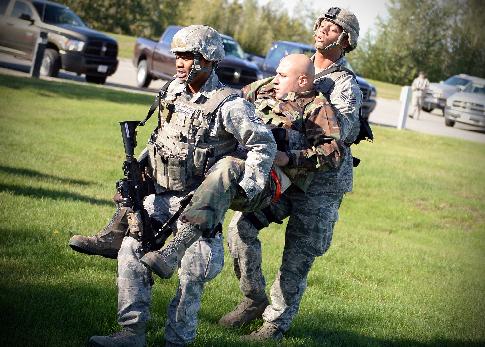 Airman 1st Class Timothy Johnson (left), 354th Security Forces Squadron response force leader, and Senior Airman Marshawn Hunter (right), 354th SFS military working dog handler, transport a simulated victim from an active shooter exercise Sept. 10, 2013, Eielson Air Force Base, Alaska. Emergency responders quickly apprehended the suspect during the scenario, which is part of the Pacific Air Forces Readiness Focused Consolidated Unit Inspection to evaluates the base on readiness and compliance with operational instructions. (U.S. Air Force photo by Senior Airman Shawn Nickel/Released)