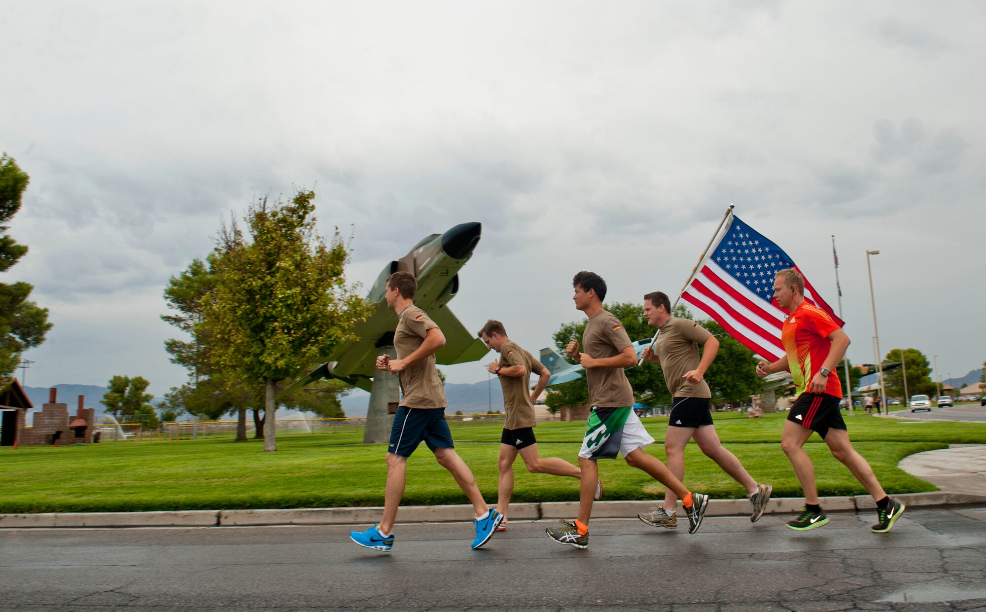 Members of the German air force carry the American flag during the 9/11 Old Glory Challenge Sept. 11, 2013, at Nellis Air Force Base, Nev. German air force members are at Nellis AFB participating in Green Flag-West 13-10. This German air force team ran with the American flag around Freedom park for an hour.  This event was sponsored by the Top III and Team Red White and Blue Las Vegas. (U.S. Air Force photo by Senior Airman Daniel Hughes)