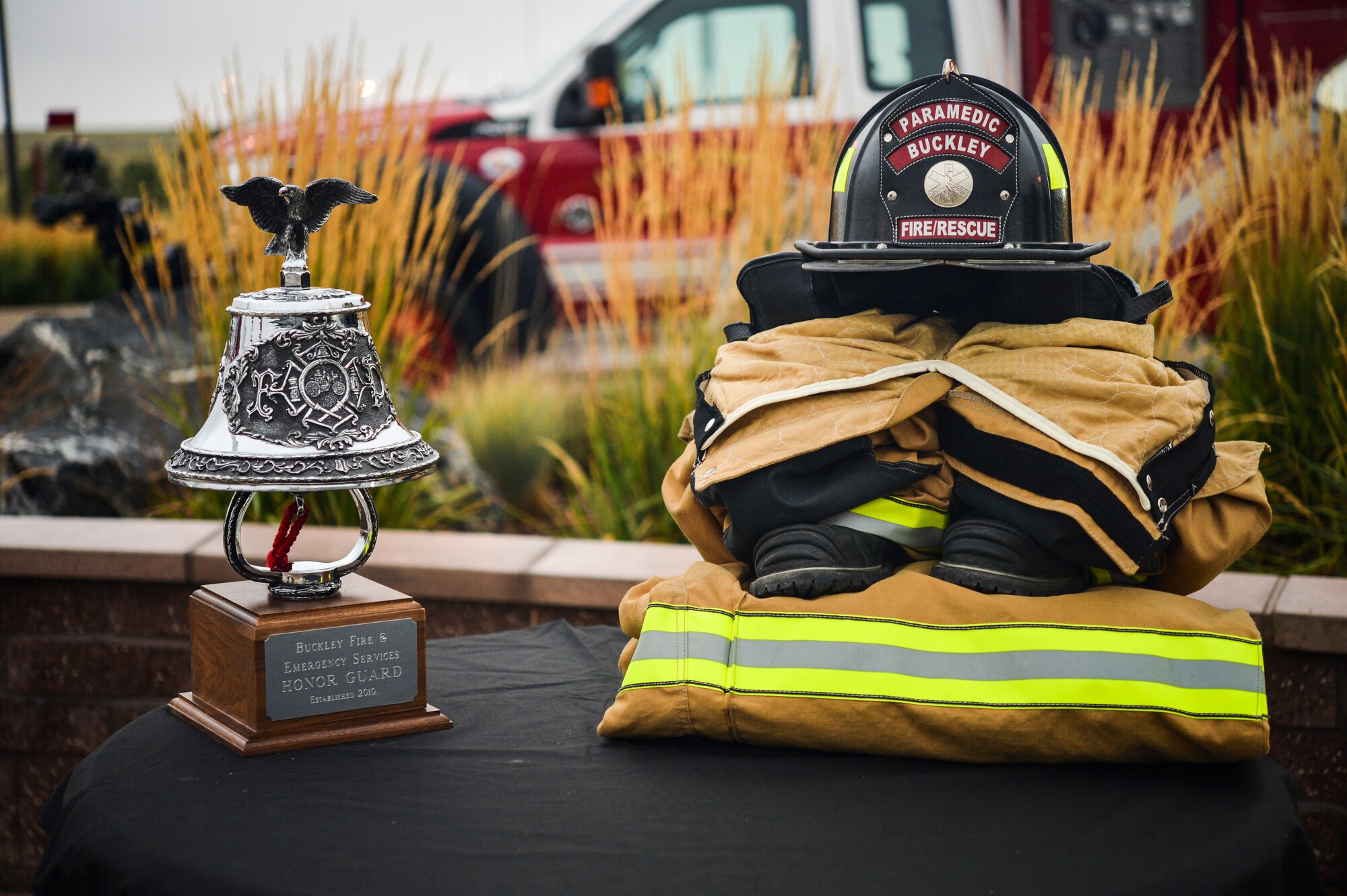 A firefighter’s uniform and a ceremonial bell are displayed at the Patriot Day and National Day of Remembrance Sept. 11, 2013 at the 460th Space Wing headquarters building on Buckley Air Force Base, Colo. The symbols were on display to honor the firefighters who lost their lives during the 9/11 attacks on the World Trade Centers in New York. (U.S. Air Force photo by Staff Sgt. Paul Labbe/Released)