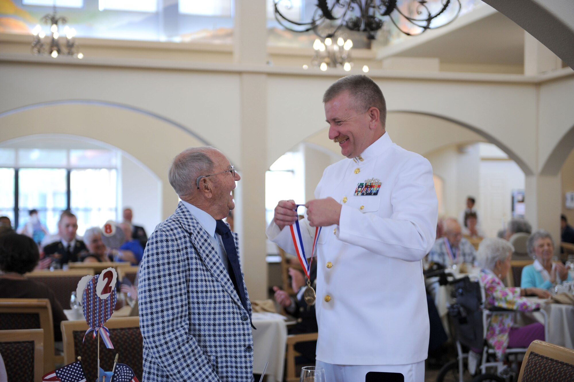 U.S. Navy Master Chief Petty Officer Steve Kennedy, Naval Operational Support Center Tucson command master chief, presents a medallion to Herbert Holly at a World War II Veterans Medallion Ceremony held at Silver Springs Senior Living Community in Green Valley, Ariz., Sept. 7, 2013. Holly served as a messenger for the U.S. Army during the war. (U.S. Air Force photo by Airman 1st Class Saphfire Cook/Released) 