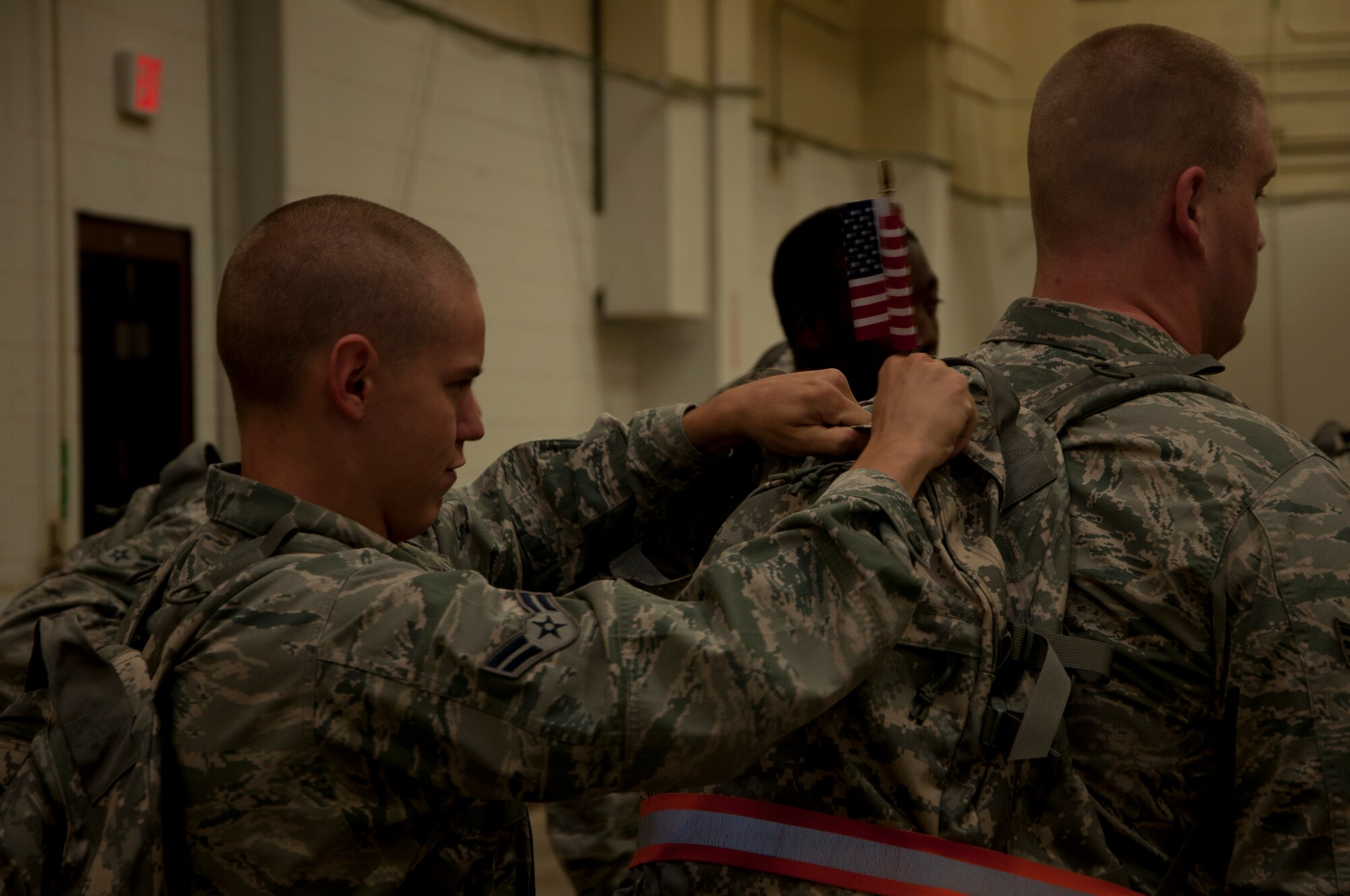 Airman 1st Class Devin Lashley, 90th Logistics Readiness Squadron, places a flag on fellow 90th LRS member Senior Airman Christopher Shipp’s ruck sack prior to a three-mile march here Sept. 11, 2013. The 3rd annual ruck march, held by the 90th LRS, began at dawn. Airmen assigned to the squadron filled ruck sacks with sandbags and marched to Warren’s main gate and the base fire department in memory of all first responders lost on 9/11. (U.S. Air Force photo by Tech. Sgt. Stacy Foster, 90th Missile Wing Public Affairs)