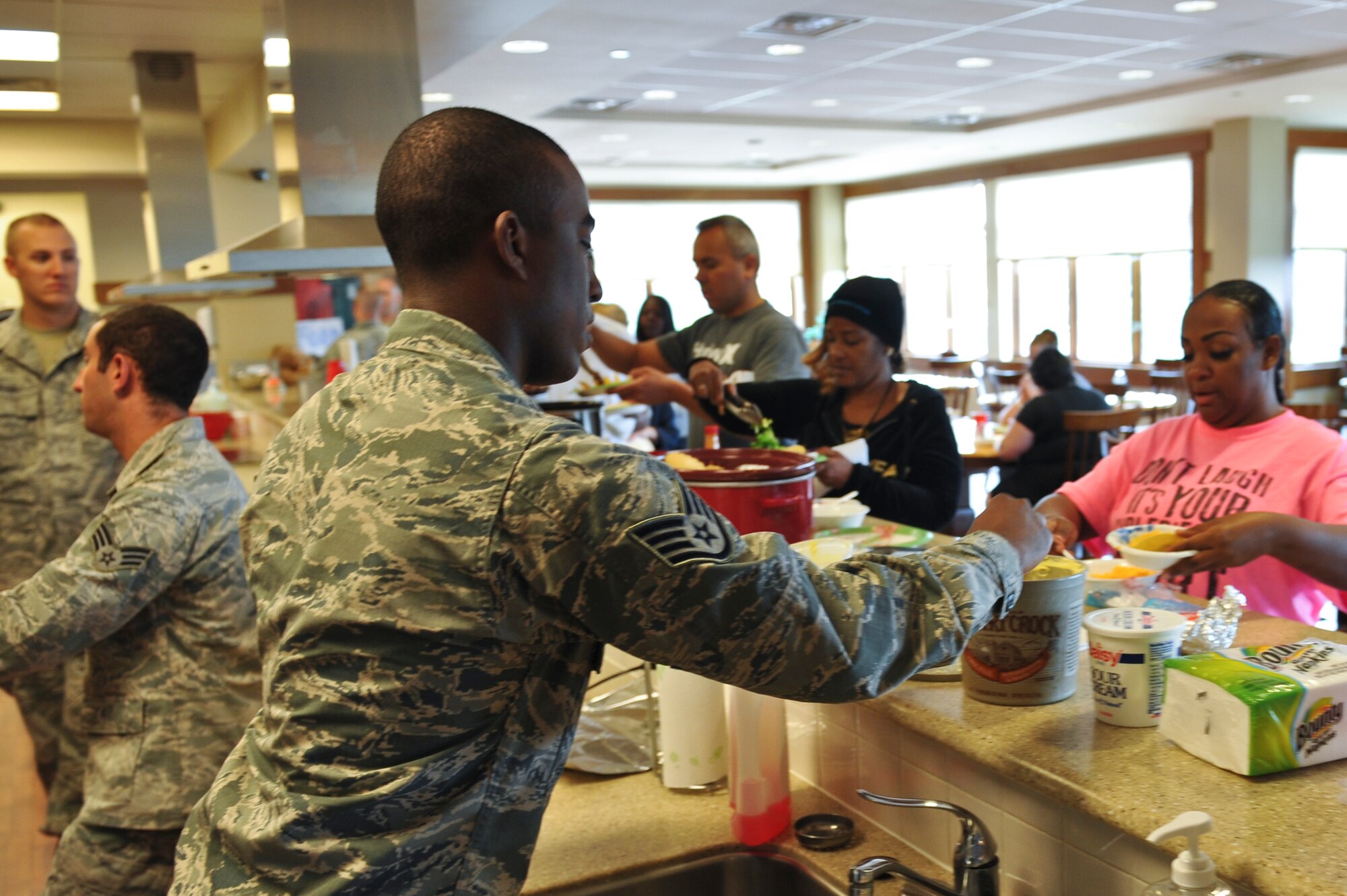 Staff Sgt. Paul Labbe, 460th Space Wing Public Affairs, serves food to families Sept. 10, 2013, at the Ronald McDonald House in Aurora, Colo. Fourteen Team Buckley members prepared tacos and baked potatoes for families staying at the Ronald McDonald House. The organization offers a home away from home for families needing to be near their seriously ill or injured children while they're being treated at nearby hospitals. (U.S. Air Force photo by Airman 1st Class Riley Johnson/Released)