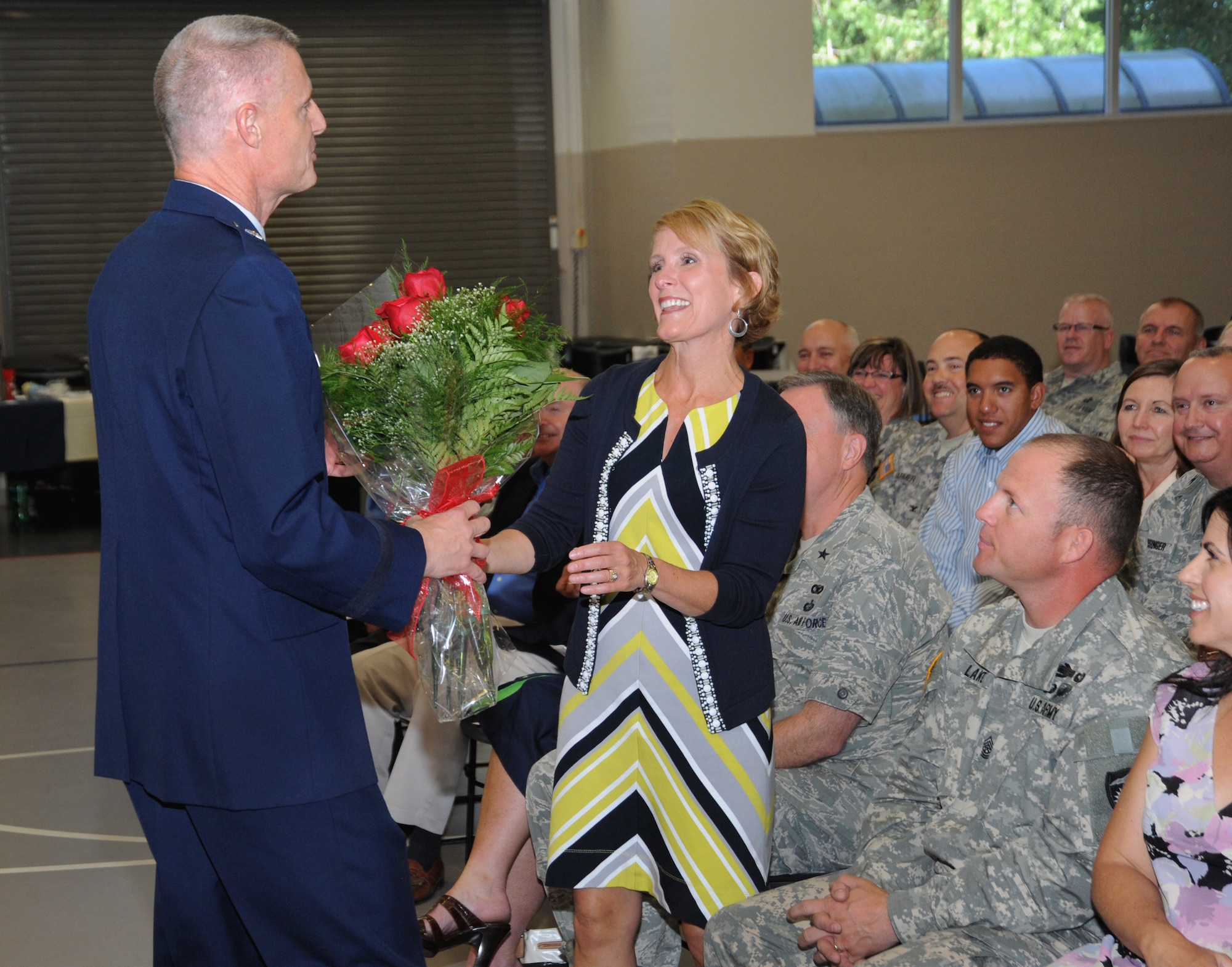 Brig. Gen. Steven Gregg presents flowers to his wife Linda Gregg, during the Change of Command and State Command Chief Change of Authority ceremony, Oregon Air National Guard held at the Anderson Readiness Center, Salem, Ore., Sept. 8, 2013. (Air National Guard photo by Tech. Sgt. John Hughel, 142nd Fighter Wing Public Affairs/Released) 