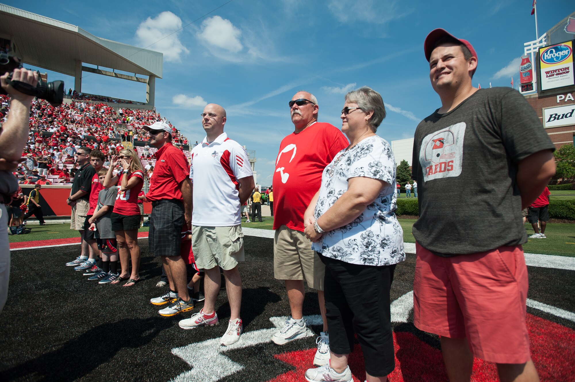 Staff Sgt. Jarrod Blanford (center, white shirt), an aerial port specialist in Kentucky Air National Guard’s 123rd Contingency Response Group, is honored for exceptional service Sept. 7, 2013, during Military Appreciation Day events held as part of the University of Louisville-Eastern Kentucky University football game at Papa John’s Cardinal Stadium in Louisville, Ky. Blanford has deployed to both Iraq and Afghanistan, where he assisted in the medical care of multiple patients who suffered amputations or burns, and prepared wounded warriors for airlift transport out of the theater. (U.S. Air National Guard photo by Maj. Dale Greer)