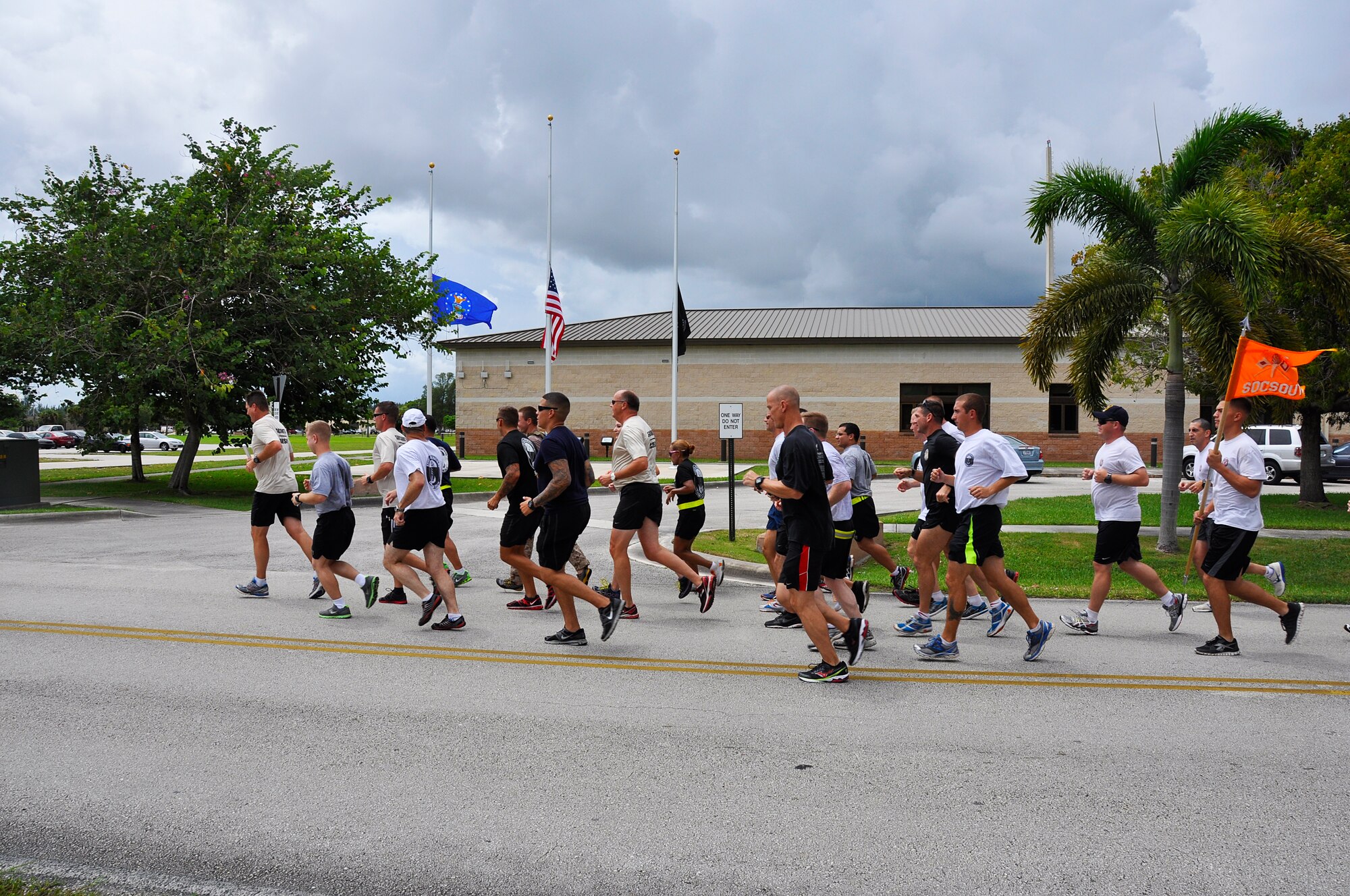 Airmen, Soldiers, Sailors and Marines assigned to the Special Operations Command South run past the HARB's flags at half staff during a 9/11 remembrance relay race, Sept. 11. The 140-mile relay race began at the southernmost point buoy in Key West, Fla., starting on Sept. 10 at 4 p.m. and concluded at HARB on Sept. 11 at 2 p.m. (U.S. Air Force photo/ Tech. Sgt. Lou Burton)