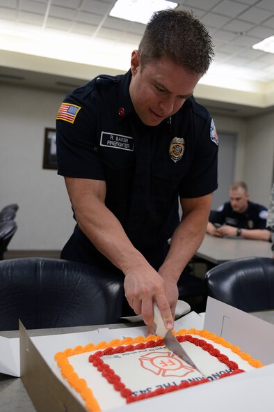 Raymond Baker, 627th Civil Engineer Squadron fire fighter, cuts a cake donated from local civic leader Paul Edwards, Sept. 11, 2013, at Joint Base Lewis-McChord, Wash. Edwards donated the cake to pay tribute to the 343 fire fighters who died responding to the Sept. 11 terrorist attacks on the World Trade Center, and to thank the fire fighters at McChord for their service. (U.S. Air Force photo/Airman 1st Class Jacob Jimenez)