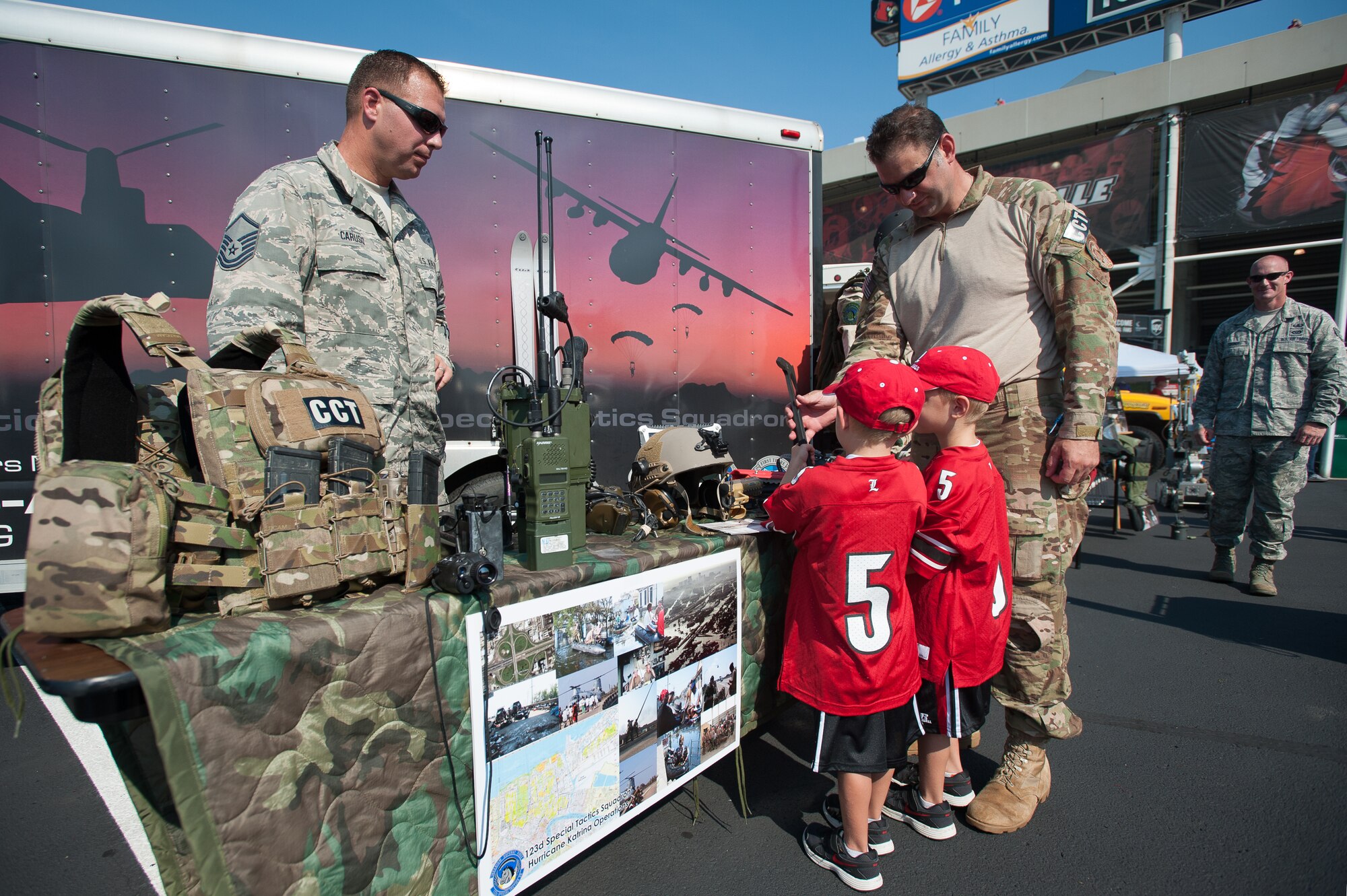 Master Sgt. Thomas Caruso, a Kentucky Air National Guard recruiter (left), and Master Sgt. Robert Fernandez, a combat controller with the Kentucky Air Guard’s 123rd Special Tactics Squadron, demonstrate special tactics gear as part of a static display of equipment prior to the University of Louisville-Eastern Kentucky University football game at Papa John’s Cardinal Stadium in Louisville, Ky., Sept. 7, 2013. U of L billed the game as Military Appreciation Day. (U.S. Air National Guard photo by Maj. Dale Greer)