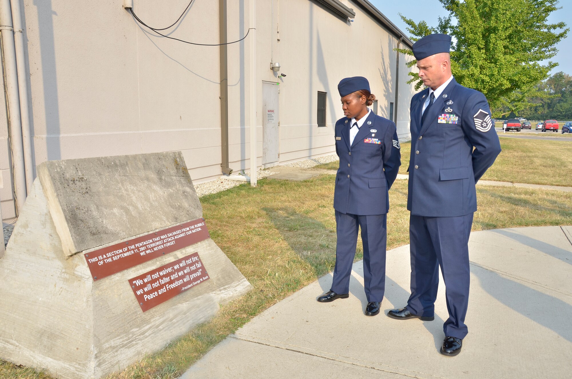WRIGHT-PATTERSON AIR FORCE BASE, Ohio – Staff Sgt. Precious Sims and Master Sgt. Michael Golden, both with the 445th Airlift Wing Chaplain Corps, reflect on the historical significance of a section of the Pentagon damaged during the September 11, 2001 attacks that is on display outside of the 445th Airlift Wing headquarters building. The wing held a Patriot Day ceremony to mark the twelfth year anniversary of the attacks. (U.S. Air Force photo/Stacy Vaughn)