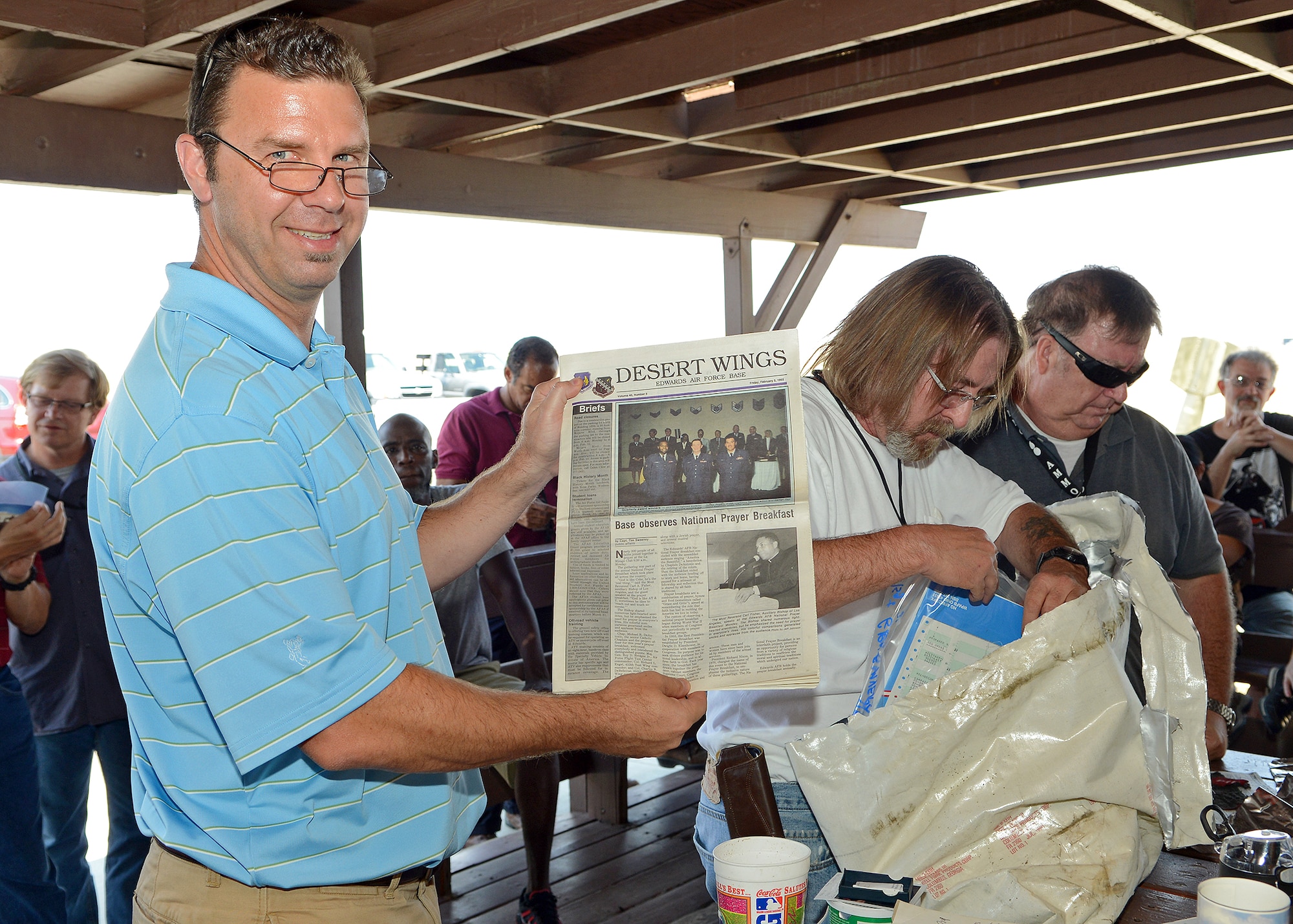 William Jones (left), the 412th MXS munitions accountable systems officer, holds up a Desert Wings issue from Feb. 5, 1993, that was extracted from a time capsule Sep. 9, 2013. The time capsule was assembled and buried by Jones and other munitions specialists from the then 6515th Munitions Maintenance Squadron at Edwards. The time capsule opening was held to reveal the progression of ammo from then to now and to reflect on ammo history at Edwards from 20 years ago. (U.S. Air Force photo by Jet Fabara)