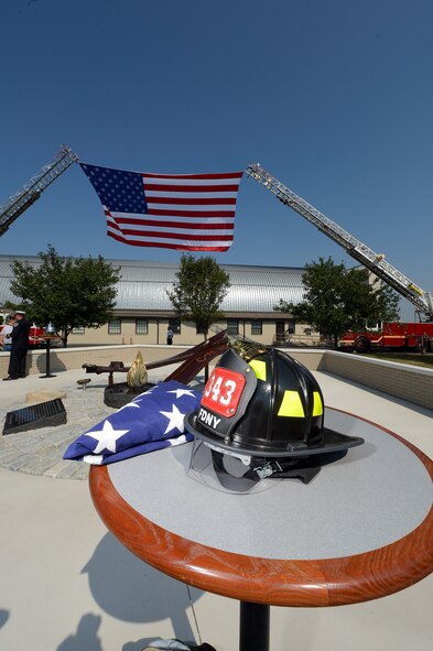 A firefighters helmet from the New York Fire Department along with a folded flag sit on a table next to the newly unveiled memorial to those killed on Sept. 11, 2001 at the Air Mobility Command museum at Dover Air Force Base, Del., Sept. 11, 2013. The memorial, which incorporates two pieces of steel from World Trade Center tower one, a rock from the United Airlines Flight 93 crash site and a block from the damaged portion of the Pentagon, makes Delaware the 50th and final state to have a public memorial. The steel was acquired through the Port Authority of New York and New Jersey World Trade Center steel program. (U.S. Air Force photo/Greg L. Davis)