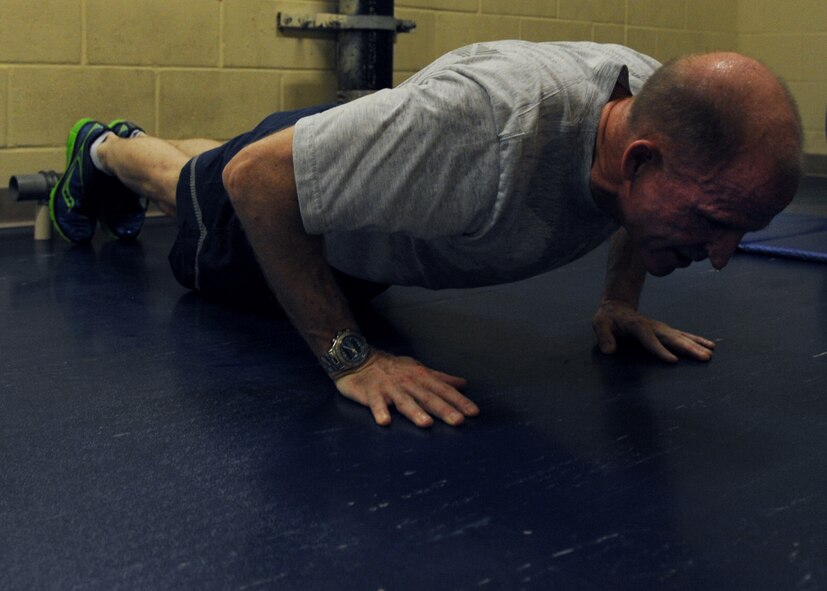 Maj. Gen. Stephen Wilson, 8th Air Force commander, performs push-ups as a part of the Air Force physical training and Iron Airman tests at the Senior Airman Bryan Bell Fitness Center on Barksdale Air Force Base, La., Sept. 9, 2013. To become an Iron Airman the challenger must receive a minimum score of 360 which includes two minutes of push-ups, sit-ups, and pull-ups, along with a two mile run, all in less than 30 minutes. (U.S. Air Force photo/Senior Airman Joseph A. Pagán Jr.)