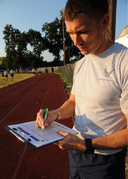Maj. Warren Carroll, 2nd Bomb Wing Commander Action Group, checks the point totals for an Iron Airman test at the Senior Airman Bryan Bell Fitness Center track on Barksdale Air Force Base, La., Sept. 10, 2013. Carroll was conducting the test for Gen. Stephen Wilson, 8th Air Force commander. The Iron Airman test is an extension of the Air Force physical training test consisting of two minutes of push-ups, sit-ups, pull-ups, and two mile run; all of which needs to be completed in less than 30 minutes. (U.S. Air Force photo/Senior Airman Joseph A. Pagán Jr.)