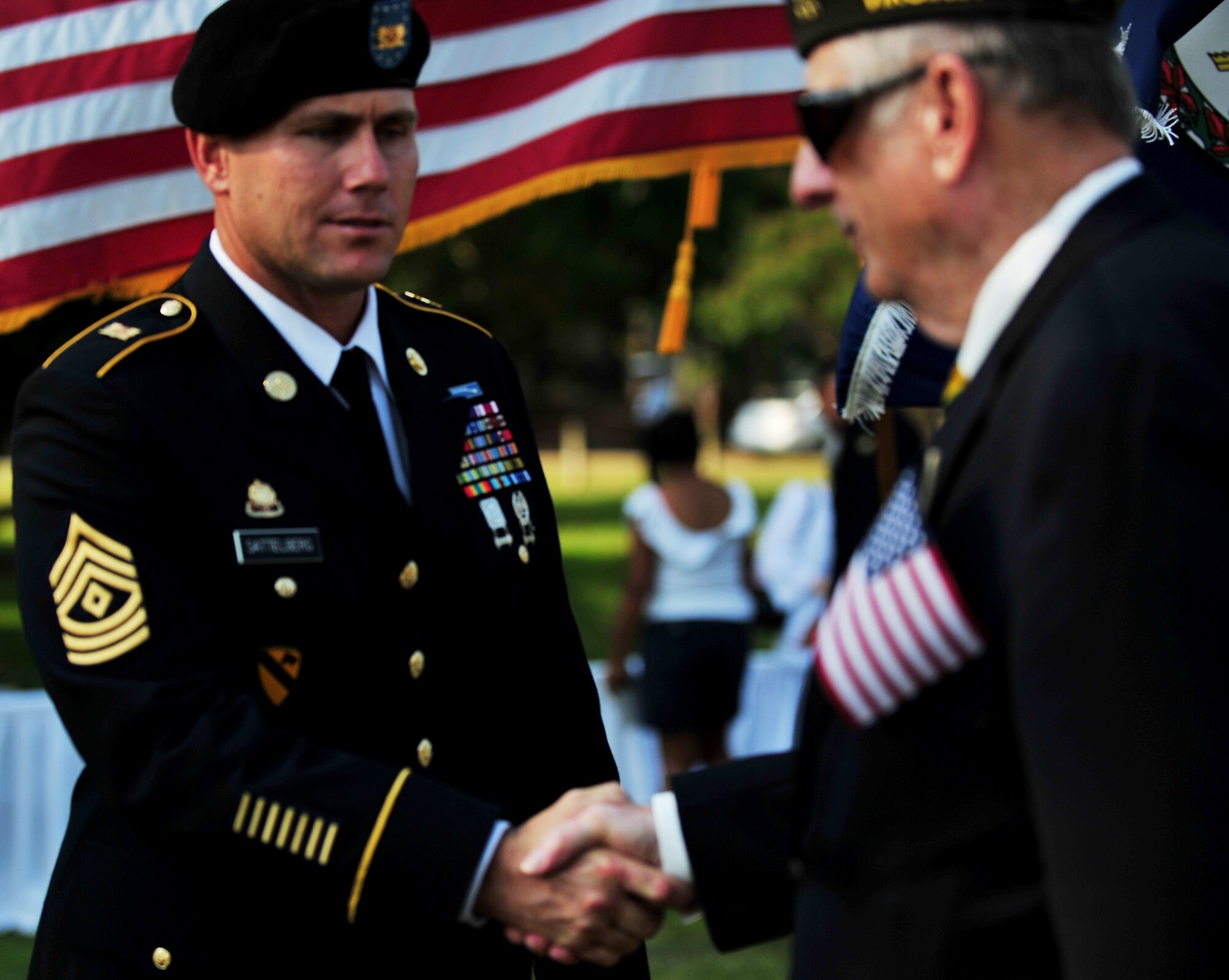 U.S. Army 1st Sgt. Ryan Sattelberg, from the 149th Seaport Operations Company, 10th Transportation Battalion, 7th Sustainment Brigade, shakes hands with a Vietnam War veteran after a remembrance ceremony at Gosnold’s Hope Park, Sept. 11, 2013. The ceremony, attended by local community residents and Service members from all branches of the military, honored those who lost their lives as a result of the 9/11 attacks. (U.S. Air Force photo by Staff Sgt. Jarad A. Denton/Released)