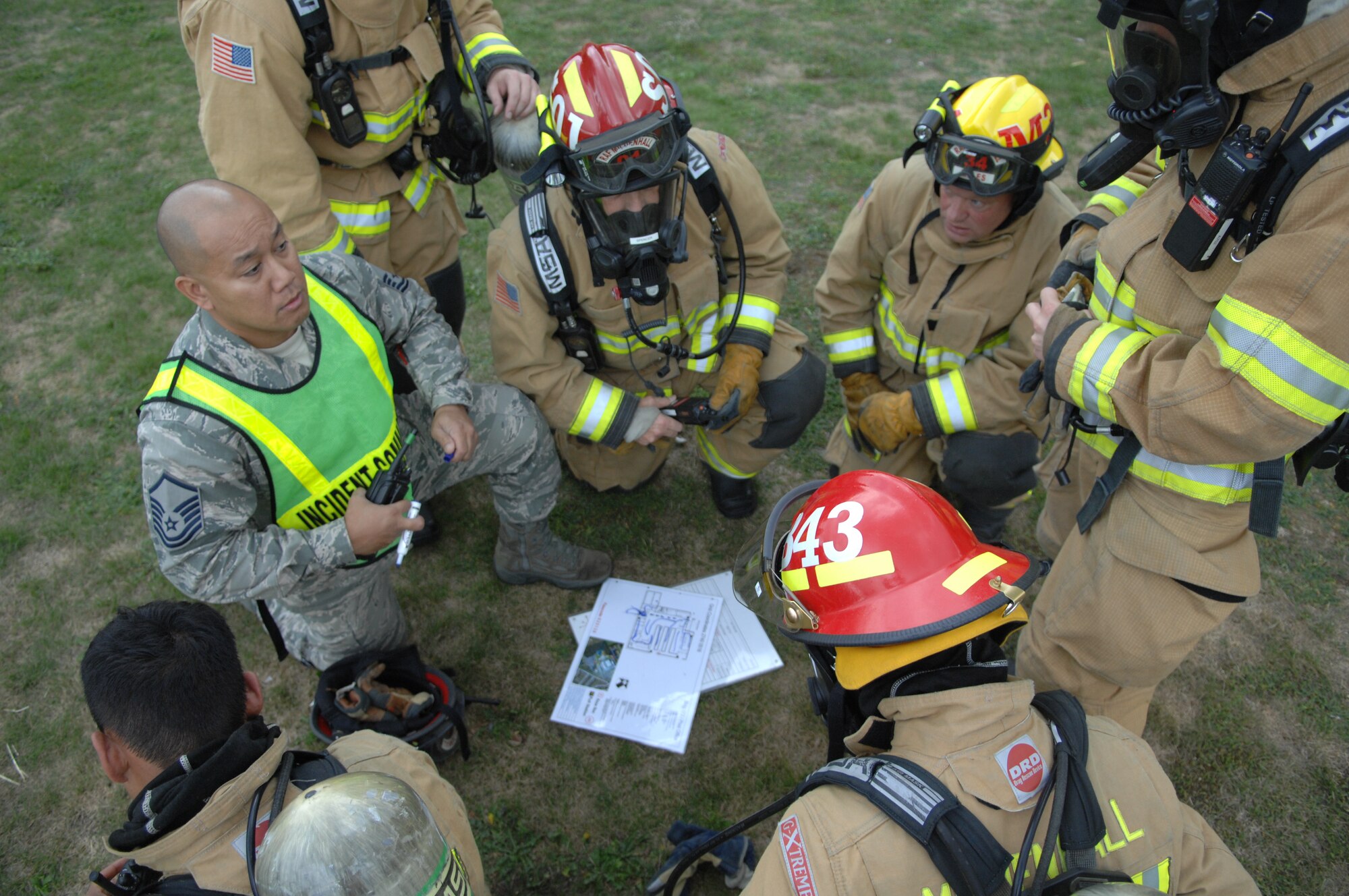 U.S. Air Force Master Sgt. Robert Ramil, left, 100th Civil Engineer Squadron Fire Department assistant chief of operations, debriefs Team Mildenhall firefighters Sept. 9, 2013, at the post office on RAF Mildenhall, England. Firefighters responded to a simulated fire in the post office as part of an operational readiness inspection for RAF Mildenhall. The exercise tested the firefighters’ abilities to extinguish a “fire” and rescue the “victims” trapped inside. (U.S. Air Force photo by Airman 1st Class Dillon Johnston/Released)