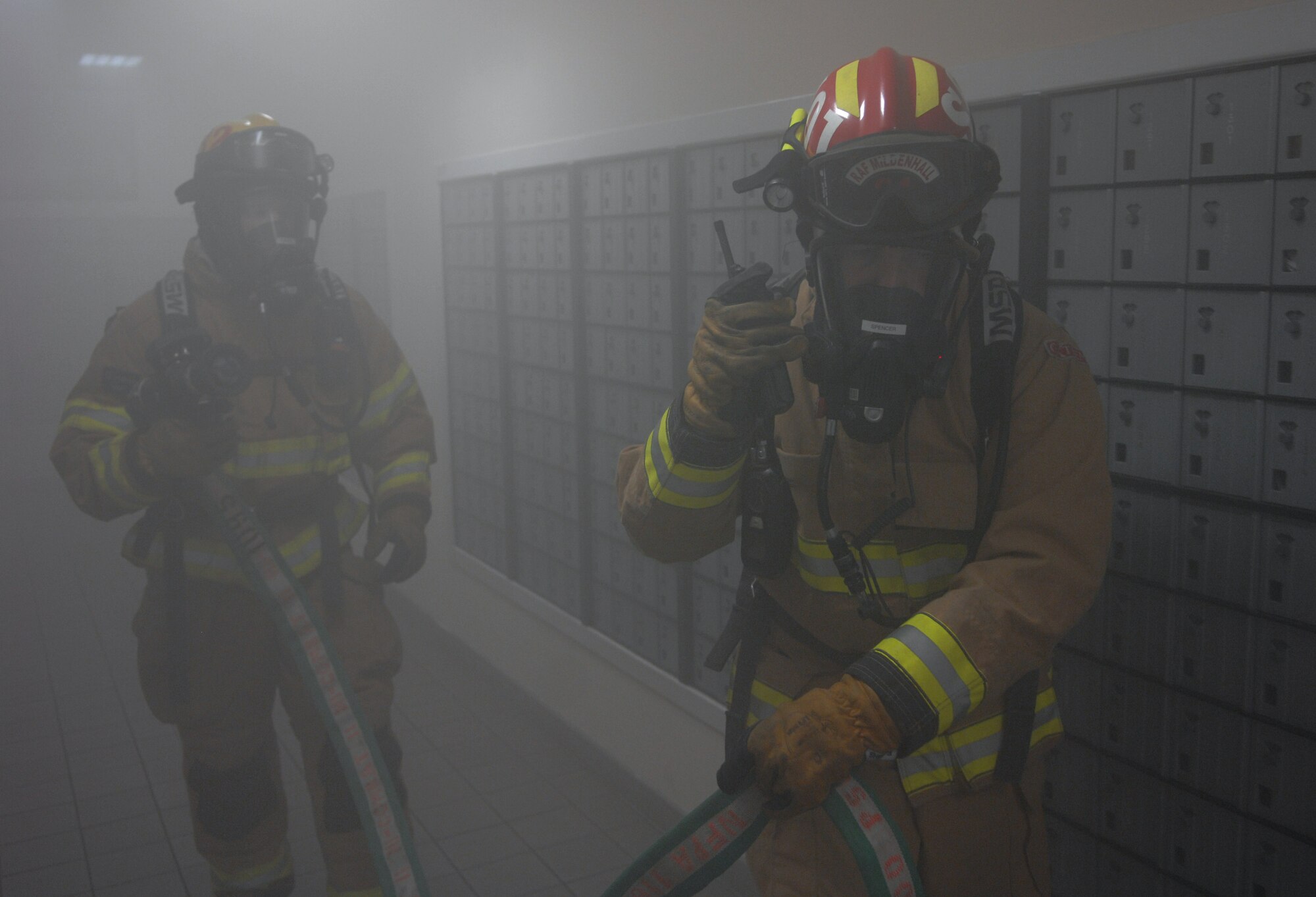 Lee Spencer, 100th Civil Engineer Squadron Fire Department crew manager, right, leads a secondary search Sept. 9, 2013, through the post office on RAF Mildenhall, England. As part of an operational readiness inspection, a mock fire exercise was conducted in the post office. After the initial sweep of the post office, firefighters went through again, searching for extensions of the original “fire.” (U.S. Air Force photo by Airman 1st Class Dillon Johnston/Released) 