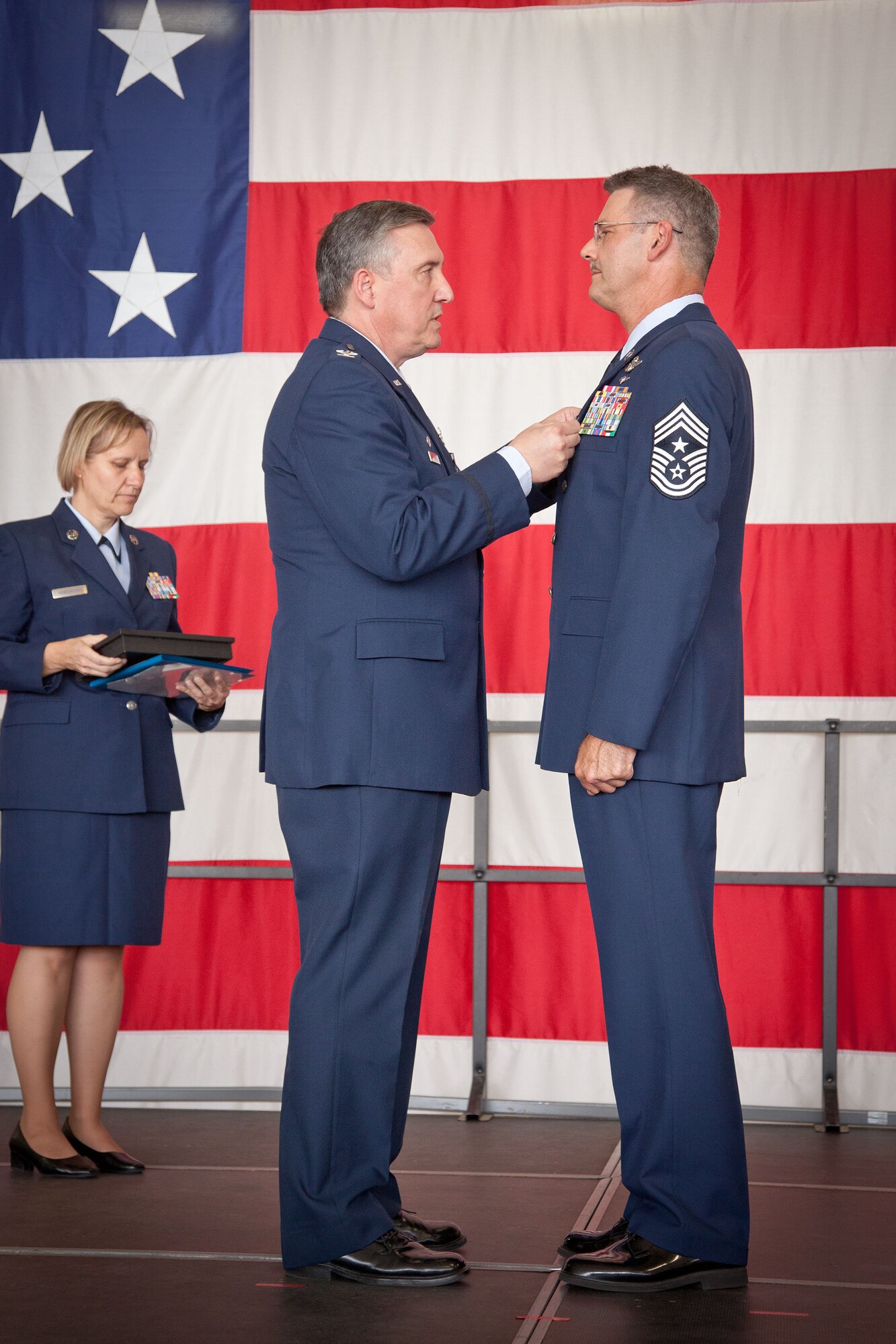 Col. Darrell Young, 934th Airlift Wing commander, presents Command Chief Master Sgt. Mark Koenig, 934 AW command chief, with his Meritorious Service Medal during his retirement ceremony.  Chief Koenig retires at the Minneapolis-St. Paul Air Reserve Station, Minn., on September 7th after over 33 years of service.  (U.S. Air Force photo/Shannon McKay)