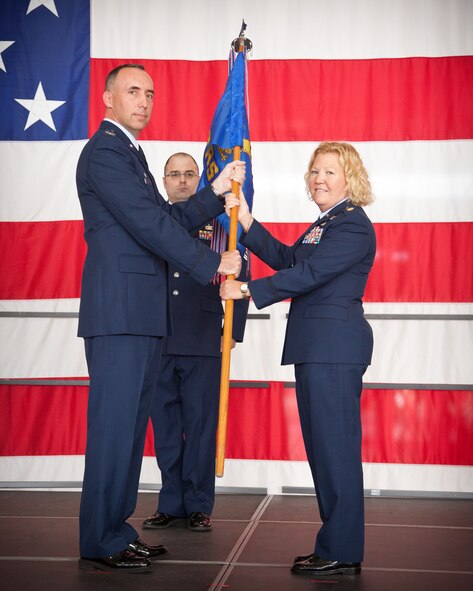 Col. Michael Burns, 934th Mission Support Group commander, presents Maj. Susan McMullen, 934th Logistics Readiness Squadron commander, with the guidon during an assumption of command ceremony at the Minneapolis-St. Paul Air Reserve Station, Minn.  (U.S. Air Force photo/Shannon McKay)