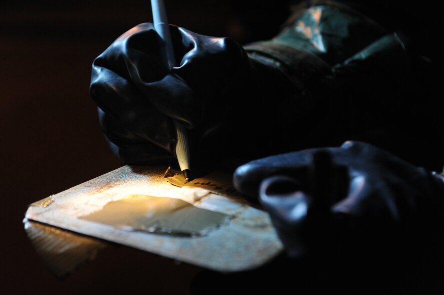A member of the 18th Communication Squadron post-attack reconnaissance team changes simulated contaminated chemical detection paper during a local operational readiness exercise on Kadena Air Base, Japan, Sept. 11, 2013. The U.S. Air Force uses paper to detect the presence of nerve and blister agents during a chemical attack. (U.S. Air Force photo by Senior Airman Malia Jenkins)