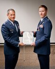 Col. Todd McCubbin, 934th Airlift Wing vice commander, presents Maj. Jason Bertino, 934th Airlift Wing Chief of Safety, with a Meritorious Service Medal during the September Unit Training Assembly's commander's call at the Minneapolis-St. Paul Air Reserve Station, Minn.  (U.S. Air Force photo/SrA Trevor Saylor)