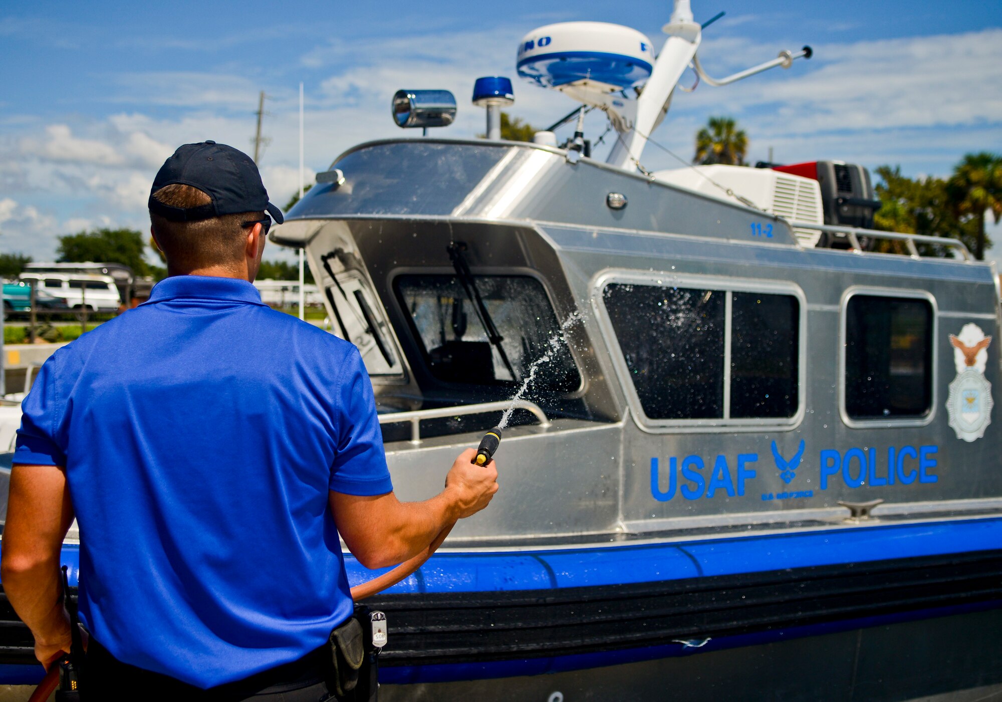 Senior Airman Cale Schumacher, crew member with the 6th Security Forces Squadron marine patrol, washes down a patrol boat at the end of his shift at MacDill Air Force Base, Fla., Sept. 5, 2013. Marine patrol Airmen must upkeep their patrol boats to ensure around-the-clock readiness. (U.S. Air Force photo by Airman 1st Class Ned T. Johnston/Released)
