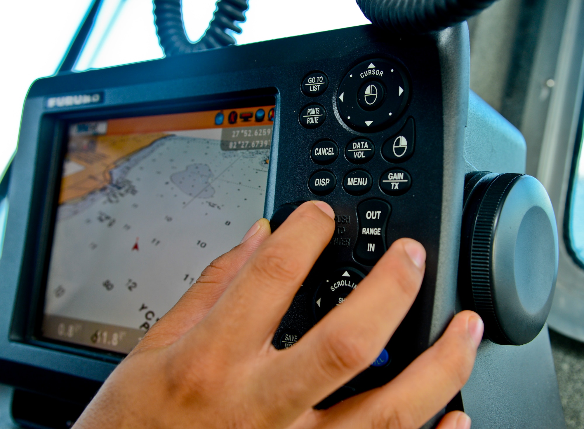 An Airman with 6th Security Forces Squadron marine patrol, dials in coordinates on a GPS while patrolling the waters around MacDill Air Force Base, Fla., Sept. 5, 2013. The 6th SFS marine patrol Airmen detect and deter any persons or vessels from entering restricted waters. (U.S. Air Force photo by Airman 1st Class Ned T. Johnston/Released)