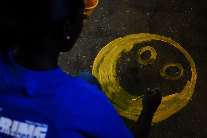 Senior Airman Poly-Bess Nagbe, 628th Aerial Medical Squadron health service management, paints a smiley face during the Trident United Way’s Day of Caring Sept. 6, 2013, at the Children's Museum of the LowCountry, Charleston, S.C. Approximately 2,500 service members from Joint Base Charleston volunteered their skills to assist with more than 50 projects in the local community. (U.S. Air Force photo/ Airman 1st Class Chacarra Neal)