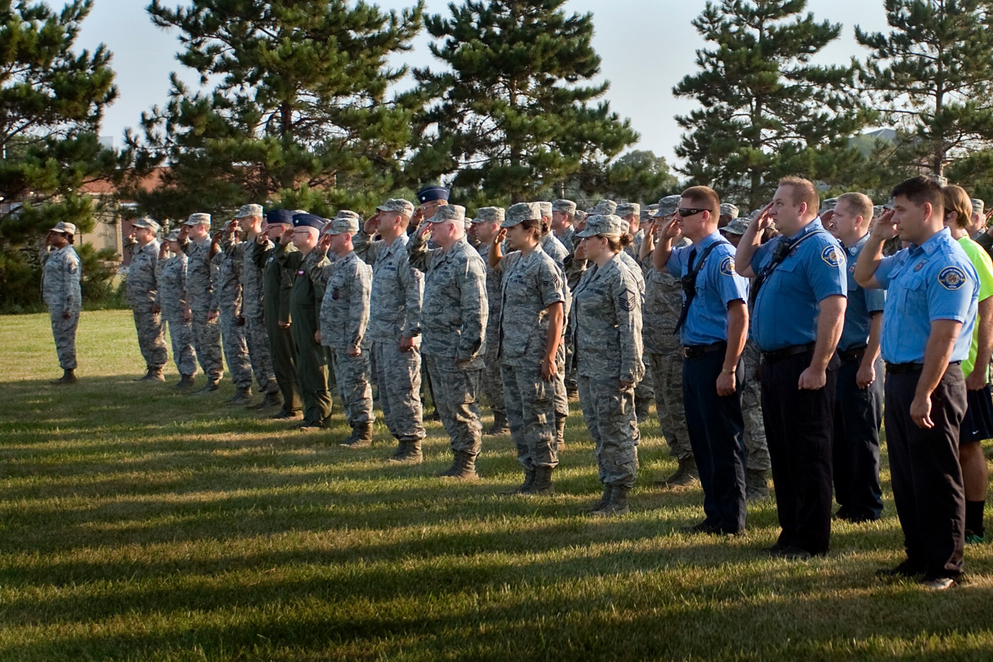 Firefighters, Airmen and civil servants pay respect to an American flag as it is raised and then lowered to half-staff during  a 9/11 remembrance ceremony at Grissom Air Reserve Base, Ind., Sept. 11, 2013. The base gathered together for the ceremony that began at 8:46 a.m., the same time the first aircraft hit the World Trade Center in 2001. (U.S. Air Force photo/Tech. Sgt. Mark R. W. Orders-Woempner) 