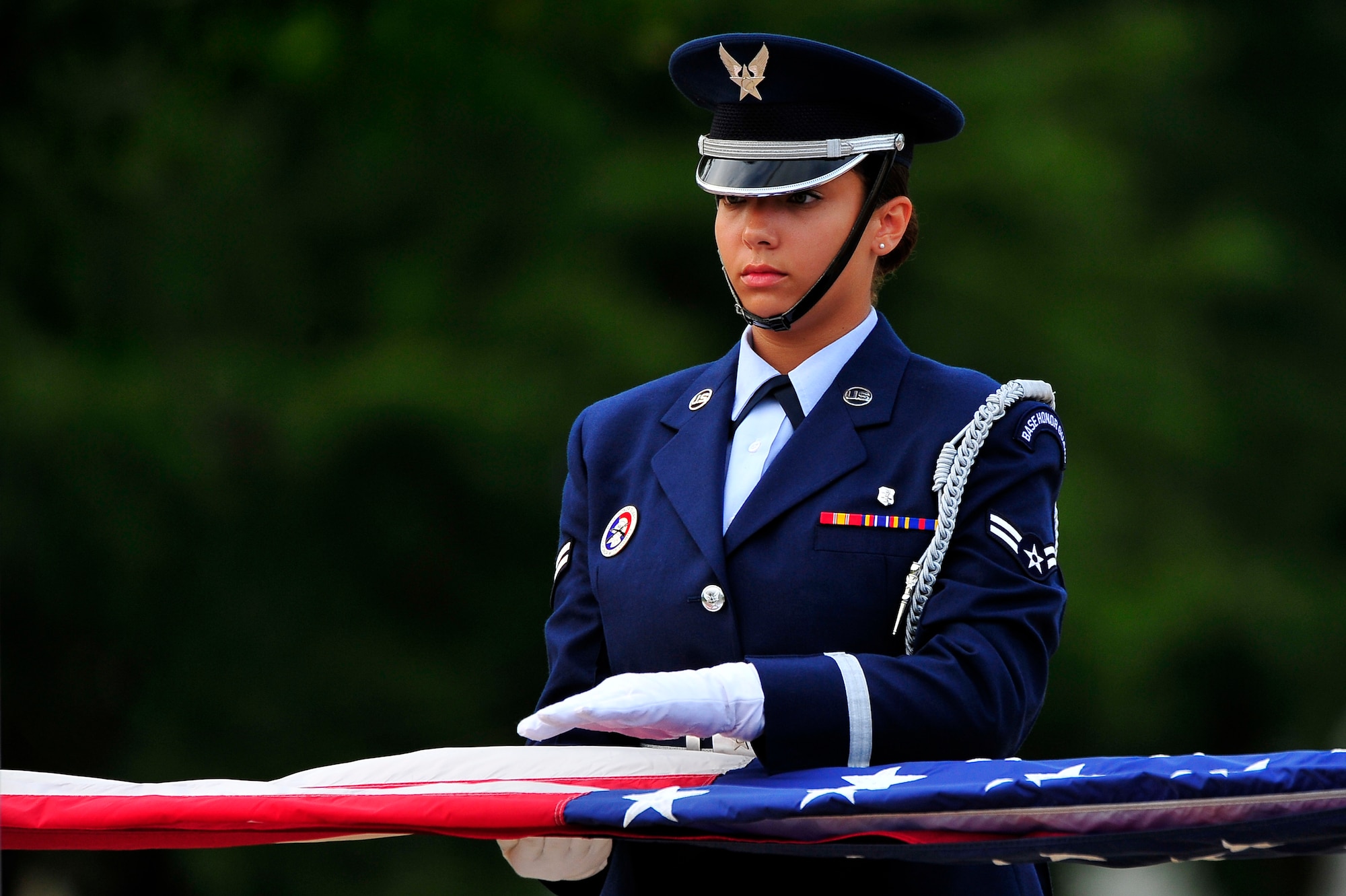 U.S. Air Force Airman 1st Class Jade Derksen, Misawa Honor Guard member, helps fold the U.S. flag during the Patriot Day Retreat Ceremony at Misawa Air Base, Japan, Sept. 11, 2013. The ceremony was held to remember the nearly 3,000 who perished in the 9/11 terrorist attacks 12 years ago. (U.S. Air Force photo by Staff Sgt. Nathan Lipscomb)  