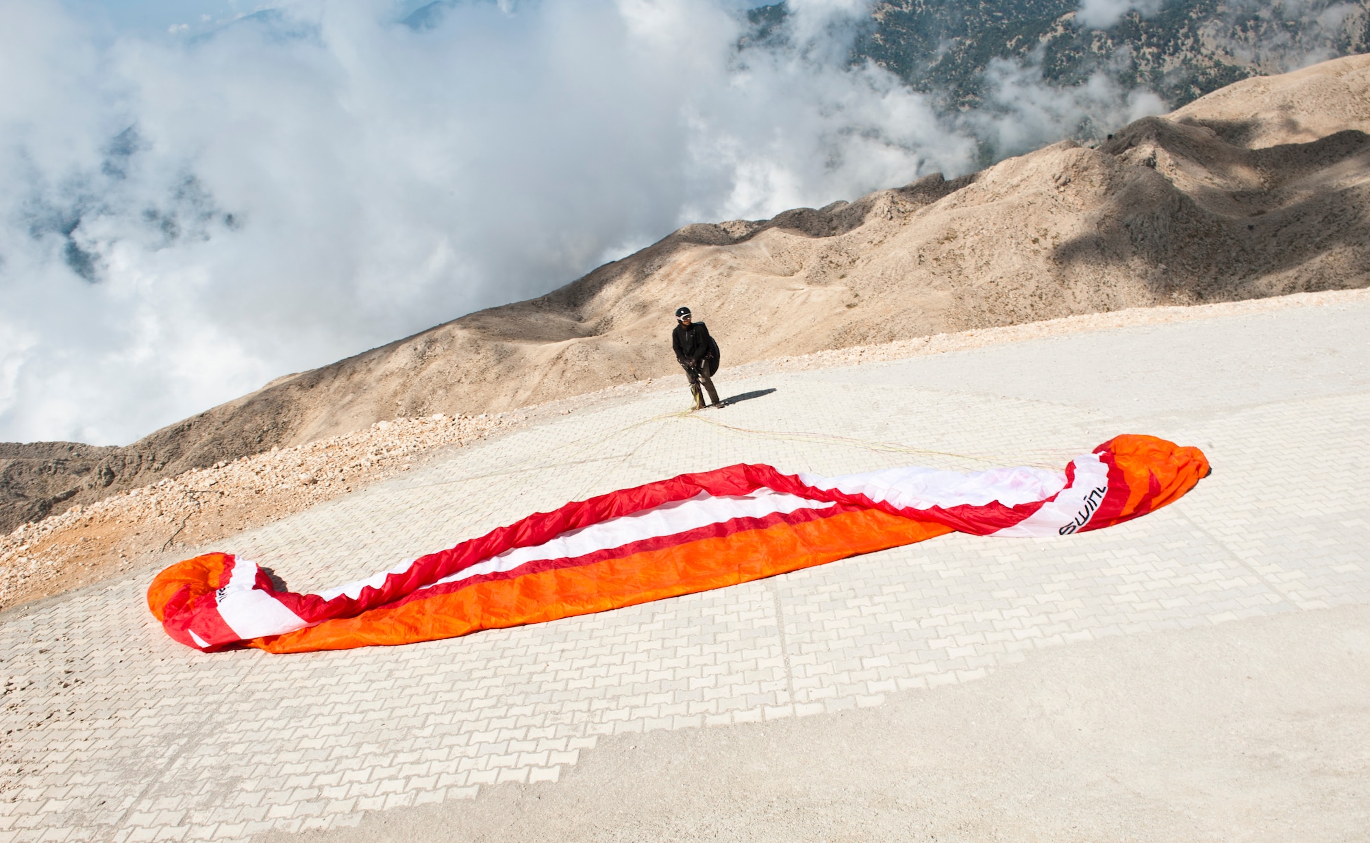 A paraglider waits for the wind to blow in the right direction atop Mount Olympos Sept. 1, 2013, near Antalya, Turkey. Visitors to Mount Olympos can take a cable car to the peak and paraglide back down for a beach landing. (U.S. Air Force photo by Senior Airman Daniel Phelps/Released)