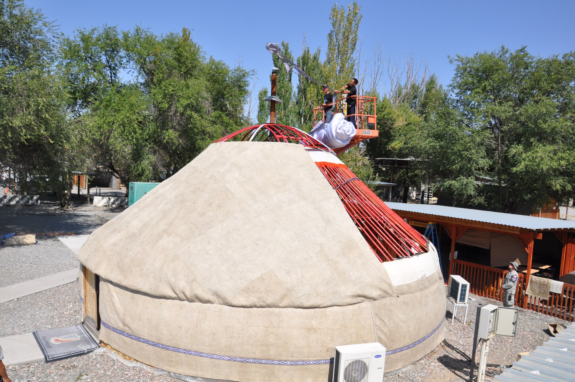 More than half way complete skilled laborers change the sheep wool cover of the nomadic-style yurt on Sept. 7, 2013 located at the Transit Center at Manas, Kyrgyzstan. The structure represents the “spirit of Kyrgyzstan” and symbolizes the friendship between the Transit Center and its local Kyrgyz neighbors. The yurt is a nomadic-type dwelling used for centuries throughout the country.   (U.S. Air Force photo/Master Sgt. Donna T. Jeffries)