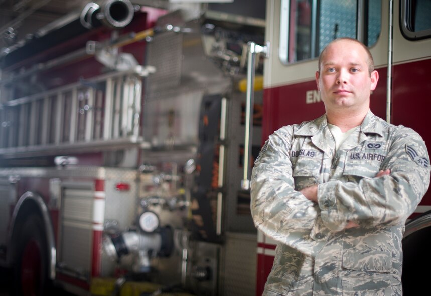 Senior Airman Jonathan Douglas, 374th Civil Engineer Squadron Fire Department driver operator, is photographed in front of a fire truck Sept. 6, 2013, at Yokota Air Base, Japan. Douglas and fellow firefighters Senior Airman Thomas Kirts and Kazuhisa Iizuka performed life saving CPR to a woman at the Fussa International Festival Aug. 31, 2013. (U.S. Air Force photo by Staff Sgt. Stacy Moless/Released)