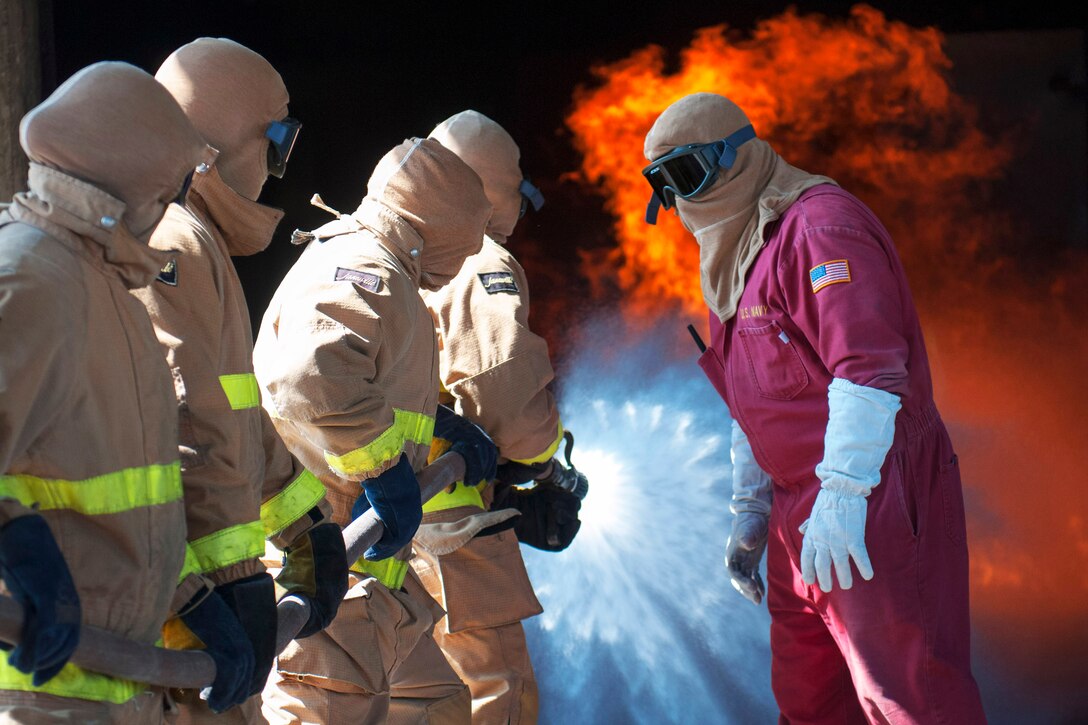 Firefighting instructors give directions to sailors during general shipboard firefighting training on Naval Base San Diego, Sept. 9, 2013. The training consisted of classroom courses and hands-on training to teach hose handling, shipboard firefighting and the use of firefighting equipment.