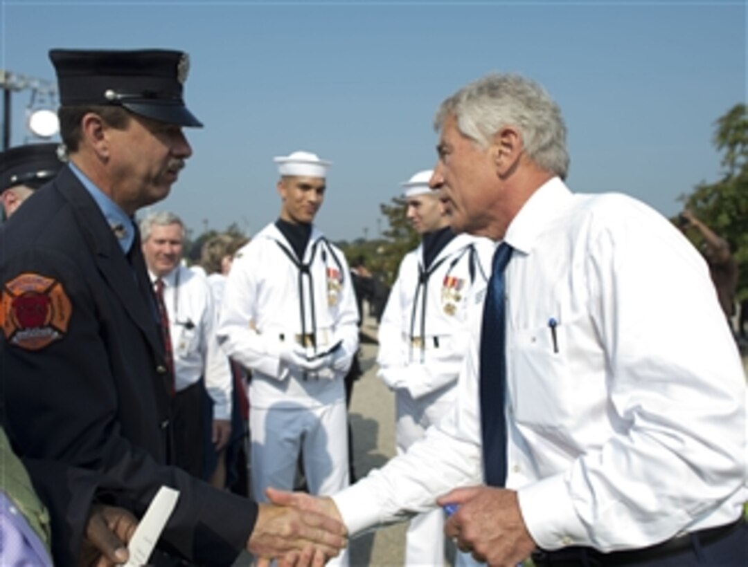 Secretary of Defense Chuck Hagel, right, greets a firefighter after a remembrance ceremony to honor the victims of the 9/11 attacks on the Pentagon in Arlington, Va., on Sept. 11, 2013.  President Barack Obama and Chairman of the Joint Chiefs of Staff Gen. Martin Dempsey joined Hagel and family members of those killed in the terrorist attack twelve years ago to remember and mark the anniversary.  