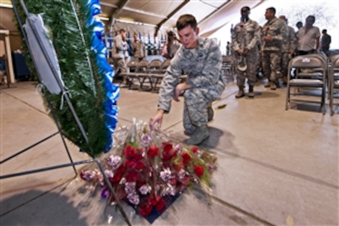 U.S. Air Force Capt. Christopher Mayor pays his respects during the 9/11 memorial ceremony at the International Transit Center in Manas, Kyrgyzstan, Sept. 11, 2013. Mayor is assigned to the 376th Air Expeditionary Wing Theater Security Cooperation. 