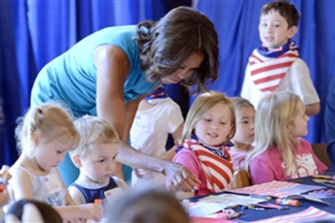 First Lady Michelle Obama helps the children of military members make crafts at the USO on Fort Belvoir, Va., Sept. 11, 2013. Obama then toured a new facility for wounded veterans who suffer from brain injuries.