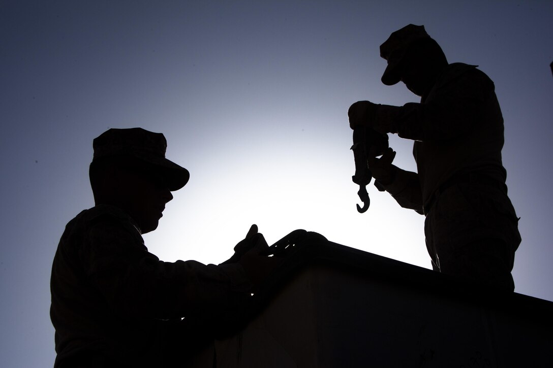 Two Marines with Combat Logistics Regiment 2, Regional Command (Southwest), unhook a cargo load at Forward Operating Base Shir Ghazi, Helmand province, Afghanistan, Aug. 27, 2013. The Marines took part in a combat logistics patrol to deliver supplies to Marines throughout the area while simultaneously conducting backhaul operations.