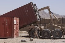 A Marine with Combat Logistics Regiment 2, Regional Command (Southwest), guides a lift-arm as it hauls a storage unit at Forward Operating Base Now Zad, Helmand province, Afghanistan, Aug. 28, 2013. The regiment took part in a combat logistics patrol to deliver supplies to Marines throughout the area while simultaneously conducting backhaul operations.