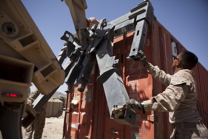 Lance Cpl. Frank Bayne, a motor vehicle operator with Combat Logistics Regiment 2, Regional Command (Southwest), guides a lift-arm as it hauls a storage unit at Forward Operating Base Now Zad, Helmand province, Afghanistan, Aug. 28, 2013. The regiment took part in a combat logistics patrol to deliver supplies to Marines throughout the area while simultaneously conducting backhaul operations.