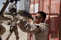 Lance Cpl. Frank Bayne, a motor vehicle operator with Combat Logistics Regiment 2, Regional Command (Southwest), guides a lift-arm as it hauls a storage unit at Forward Operating Base Now Zad, Helmand province, Afghanistan, Aug. 28, 2013. The regiment took part in a combat logistics patrol to deliver supplies to Marines throughout the area while simultaneously conducting backhaul operations.