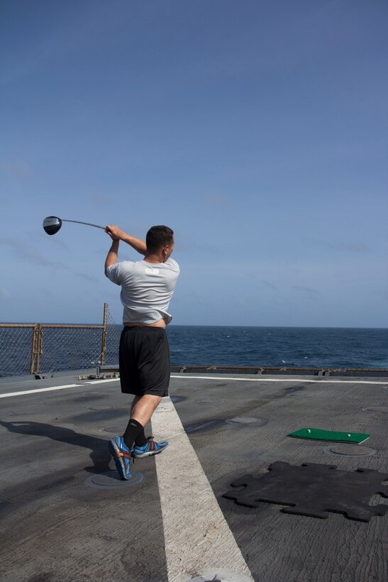 U.S. Marine Corps Lance Cpl. Jason Holman, team leader from Finksburg, Md., assigned to Company K, Battalion Landing Team 3/2, 26th Marine Expeditionary Unit (MEU), hits a golf ball off the flight deck of the USS Carter Hall (LSD 50) during a cookout while at sea, Aug. 31, 2013. The 26th MEU is a Marine Air-Ground Task Force forward-deployed to the U.S. 5th Fleet area of responsibility aboard the Kearsarge Amphibious Ready Group serving as a sea-based, expeditionary crisis response force capable of conducting amphibious operations across the full range of military operations. (U.S. Marine Corps photo by Cpl. Michael S. Lockett/Released)