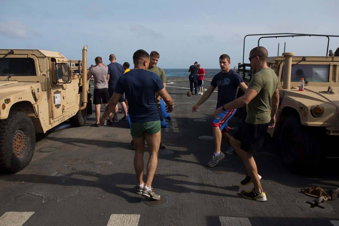 U.S. Marines and Sailors assigned to the 26th Marine Expeditionary Unit (MEU) play hacky sack during a cookout on the flight deck of the USS Carter Hall, while at sea, Aug. 31, 2013. The 26th MEU is a Marine Air-Ground Task Force forward-deployed to the U.S. 5th Fleet area of responsibility aboard the Kearsarge Amphibious Ready Group serving as a sea-based, expeditionary crisis response force capable of conducting amphibious operations across the full range of military operations. (U.S. Marine Corps photo by Cpl. Michael S. Lockett/Released)