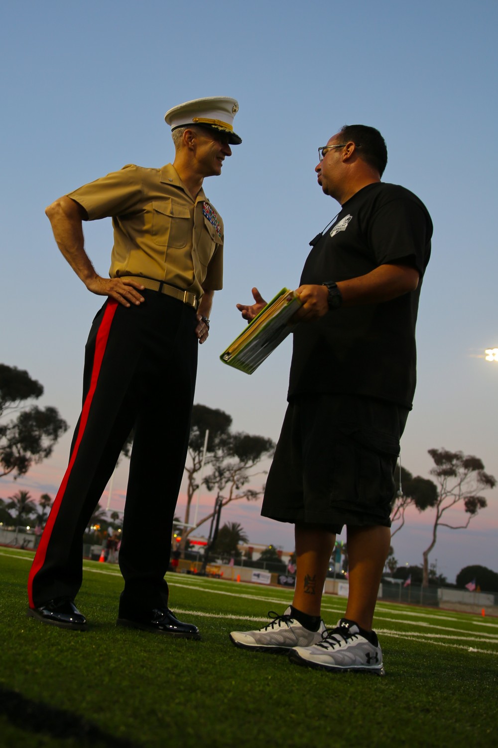 Brigadier Gen. John Bullard, commanding general, Marine Corps Installations West and Marine Corps Base Camp Pendleton, talks to Mark Soto, the founder of the Honor Group before kickoff of the Saturday night football game here, Sept. 7, 2013. Brigadier Gen. Bullard was one of the guests of honor and received the game ball prior to the coin toss. The game was part of the Honor Bowl, a two-day event put together by the Honor Group to raise awareness of the sacrifices of servicemembers.