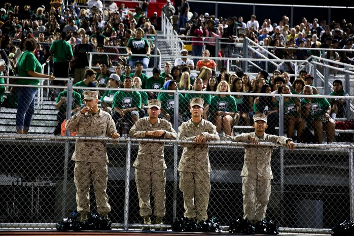 Marines with 3rd Battalion, 5th Marine Regiment, watch a local high school football game during the Honor Bowl here, Sept. 6, 2013. The Marines provided security and answered questions at a static display put together by the battalion. The Saturday night game honored the Marines and their families who served with the battalion.