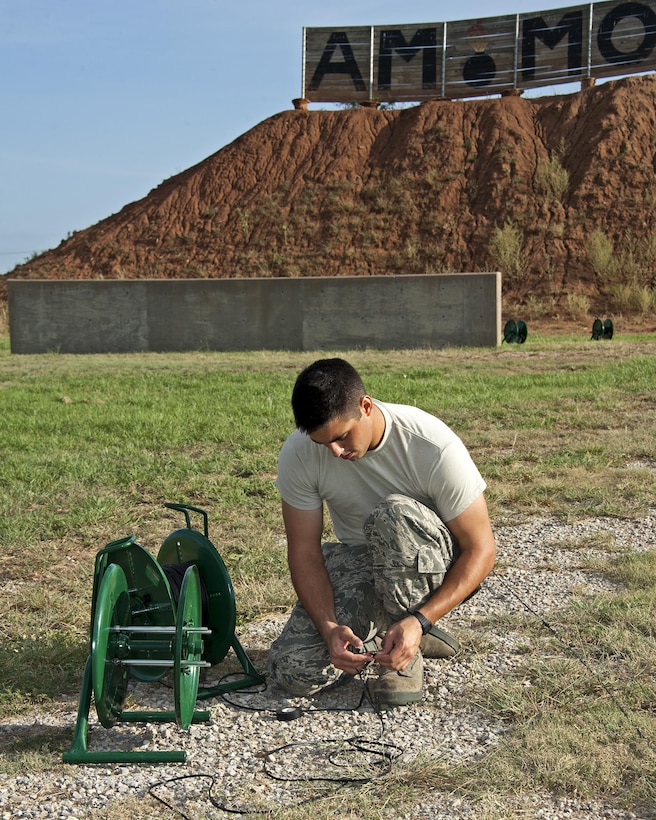 Airman Camden Durant is splicing firing wire as he prepares to detonate C-4 explosives Aug. 26, 2013, at Sheppard Air Force Base, Texas. Durant is enrolled in the 366th Training Squadron, Explosive Ordnance Disposal course. (U.S. Air Force photo/Frank Carter)