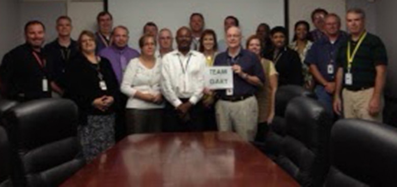 Corps employee Gary East shares a “Team Gary” sign with co-workers at Huntsville Center in August