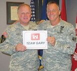 Huntsville Center Commander, Col. Robert Ruch and Corps Deputy Commanding General for Military and International Operations, Maj. Gen. Kendall Cox hold up  “Team Gary” sign in July at Huntsville Center.