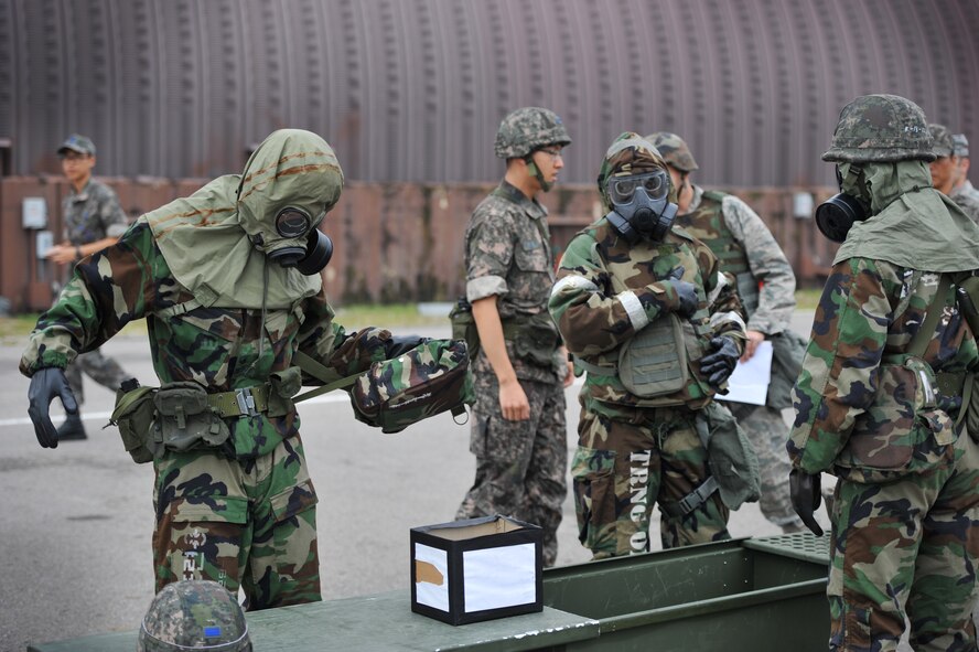 U.S. Air Force Staff Sgt. Beniteau Fenelus, center,  51st Civil Engineer Squadron emergency management readiness technician, and Republic of Korea Airmen go through contamination control area procedures during a joint chemical, biological, radiological, nuclear and explosives exercise at Osan Air Base, ROK, Sept. 12, 2013. Joint training is conducted in order to improve working relationship between the two services.  (U.S.  Air Force photo/Staff Sgt. Emerson Nuñez)